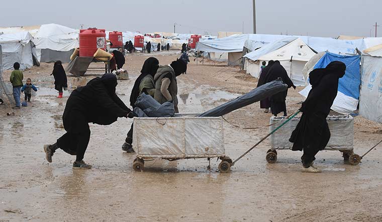 In for the long haul: Inmates carting rations in the Al-Hol camp in northeast Syria.