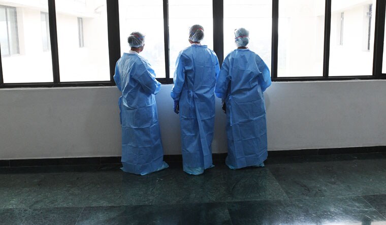 Window to the world: Nurses take a break during their shift. They cannot step out of the ward, or
their PPE suit, till their shift ends