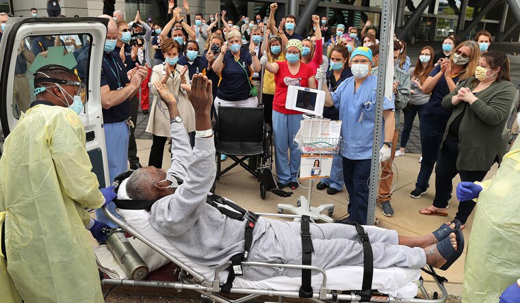 All cheer: Nurses and doctors of Boston Hope field hospital, which treated Covid-19 patients for a few months, bid farewell to a 78-year-old patient following his discharge | Getty Images