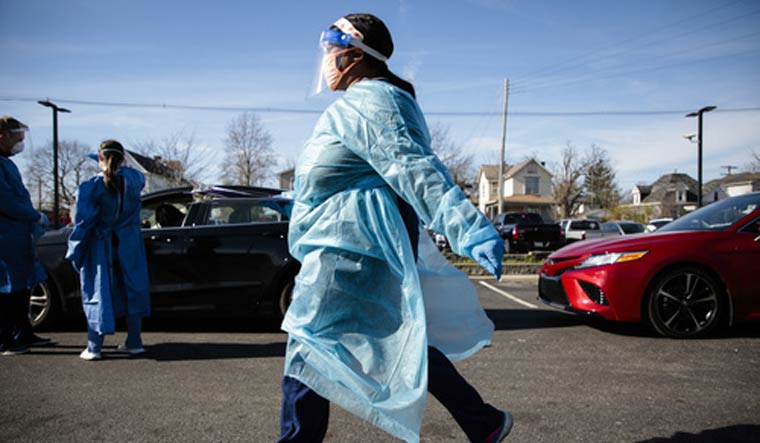 A nurse carries a COVID-19 test back for processing on Thursday, Nov. 19, 2020 at PrimaryOne Health in Columbus, Ohio | Joshua A. Bickel /The Columbus Dispatch via AP