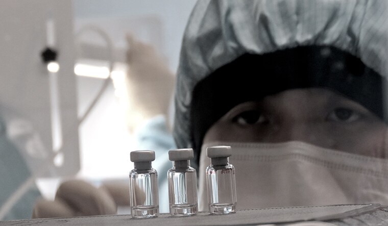 A scientist checks quality control of vaccine vials for correct volume at the Clinical Biomanufacturing Facility (CBF) in Oxford, Britain, April 2, 2020. Picture taken April 2, 2020. Sean Elias/Handout via REUTERS THIS IMAGE HAS BEEN SUPPLIED BY A THIRD PARTY. MANDATORY CREDIT. NO RESALES. NO ARCHIVES