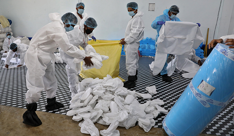 Covering all the bases: Workers packing protective gear in a workshop in Kolkata | Reuters