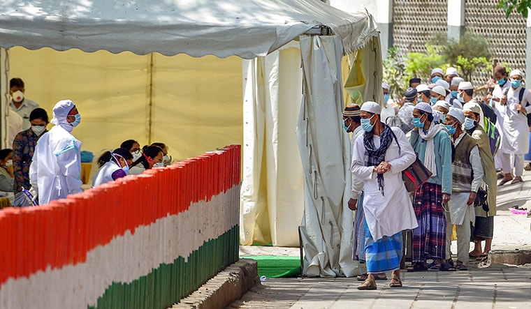 New Delhi: People who attended Tabligh-e-Jamaat congregation in Nizamuddin West board walk to board a bus for the LNJP Hospital for screening and COVID-19 test, in New Delhi, Tuesday, March 31, 2020. 24 people who took part in the congregation have tested COVID-19 positive. (PTI Photo/Vijay Verma) (PTI31-03-2020_000052B)