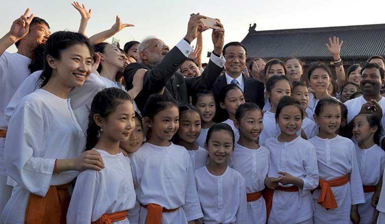Picture imperfect: Narendra Modi and China’s Premier Li Keqiang take a selfie with children during a tai chi and yoga event in Beijing in 2015 | Reuters