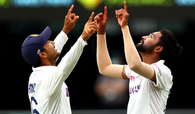 Swinging it: Siraj celebrating his fifth wicket with Mayank Agarwal on day four at the Gabba | AFP