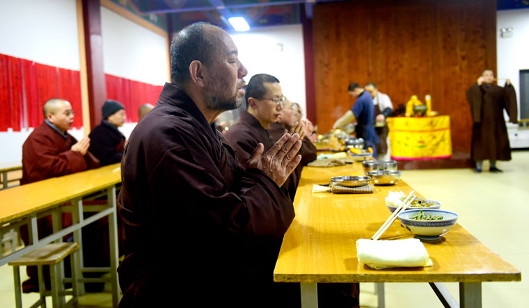 Scholar monks praying before eating lunch at the Ch’an Hall of the temple 
