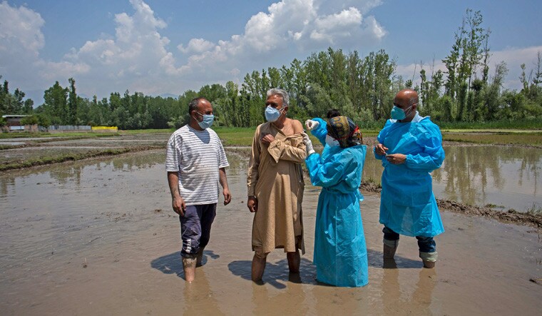 Field jab: A man receives a vaccine from a health worker in a paddy field in south Kashmir’s Pulwama district | Getty Images
