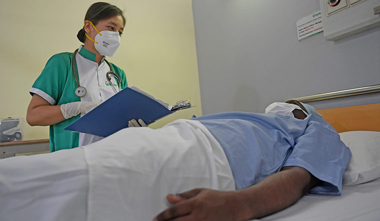 Checking in: Sapna Gurung with a patient in the general ward at Hiranandani Hospital in Navi Mumbai | Amey Mansabdar