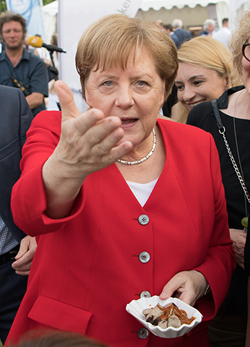 Street delight: Former German Chancellor Angela Merkel with a bowl of curry wurst | Getty Images