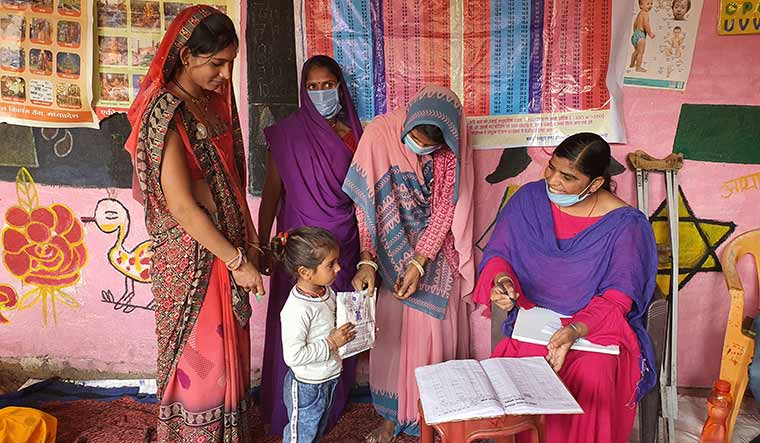 Checking in: Ramkalan (sitting) during her routine rounds amid the pandemic | Rakesh Malaviya