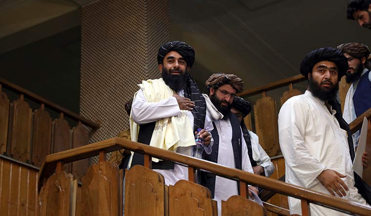 New beginning: Taliban spokesman Zabihullah Mujahid (left) arrives for his first news conference at the Government Media Information Center in Kabul | AP