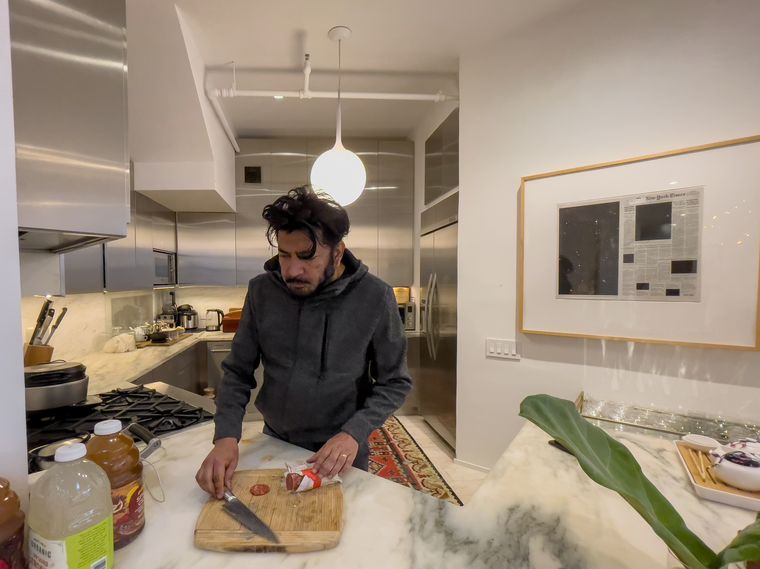 Grabbing a bite: Mukherjee makes a sandwich at his New York home.
