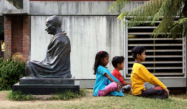 Inspired by bapu: Children playing near the statue of Mahatma Gandhi at Sabarmati Ashram, Ahmedabad | Dinodia