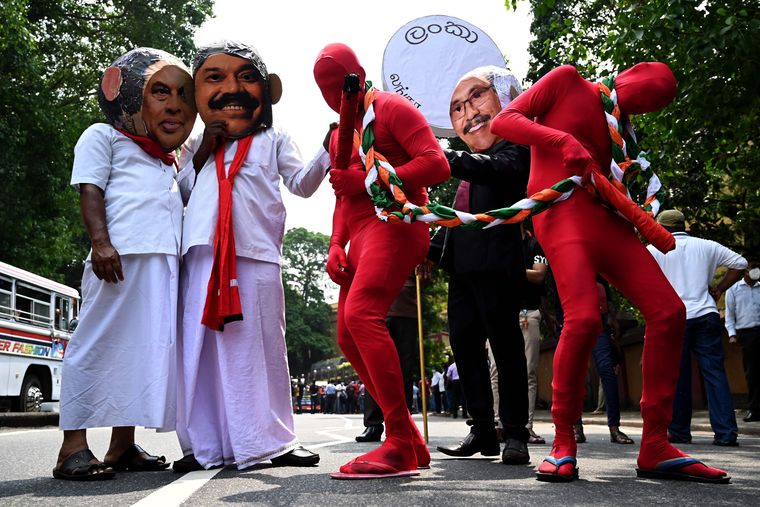Out of favour: Leftist activists wearing masks of the Rajapaksas in a protest in Colombo | AFP