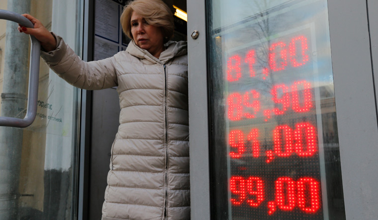 Free fall: A woman leaves an exhange office in Moscow. Sanctions have hit the rouble hard | AP