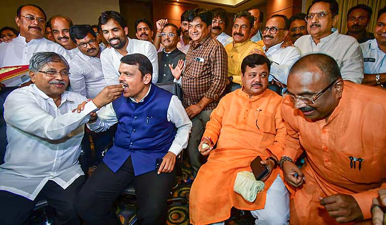 Victors and the vanquished: State BJP president Chandrakant Patil giving sweets to Devendra Fadnavis after Uddhav’s resignation on June 29 | PTI