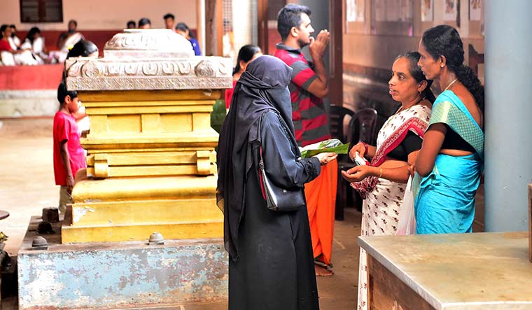 Bless me, Lord Subrahmanya!: Fathima B. (in purdah) at the Kumaramangala temple in Kasargod, Kerala | Jibin Chempola