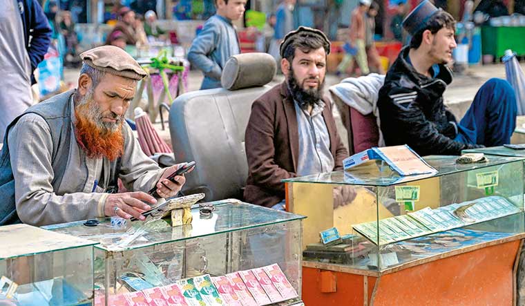 Zero-sum game: Money changers wait for customers at the Torkham border crossing between Pakistan and Afghanistan | AFP