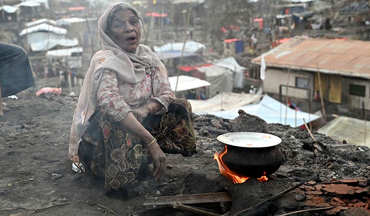 Burning pain: A Rohingyan woman cooks outdoors after her shanty at a refugee camp in Cox’s Bazar was destroyed in a recent fire.