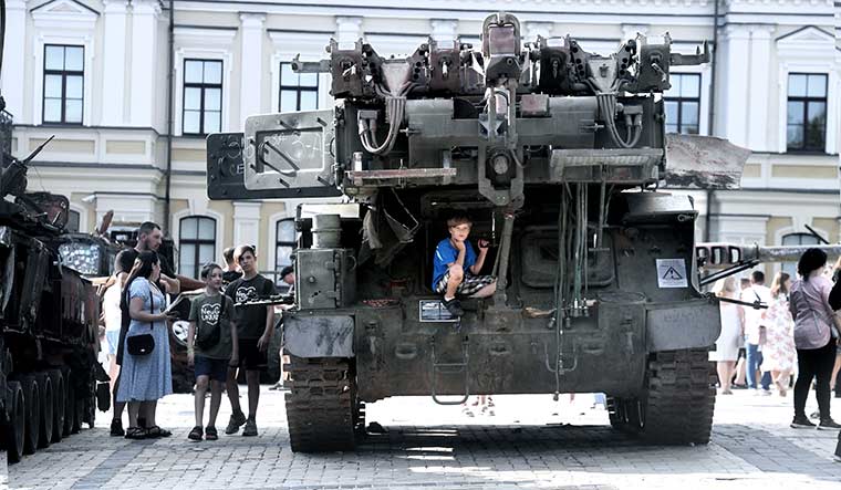 50-A-boy-sitting-on-a-damaged-Russian-armoured-vehicle