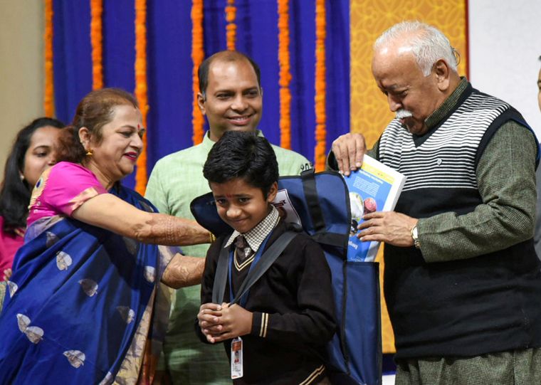 Catch them young: RSS chief Mohan Bhagwat and Union Minister Nitin Gadkari’s wife, Kanchan, present books to a student in Nagpur | PTI
