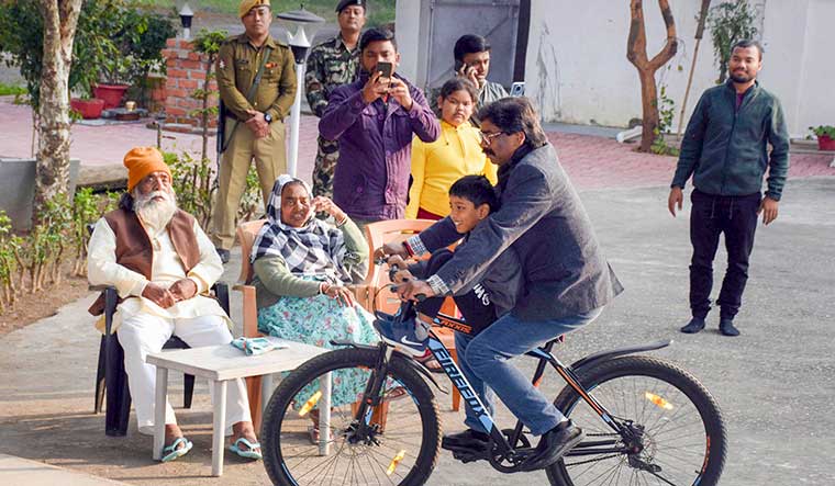 Riding high: hemant soren rides a bicycle at his residence, as his father and party chief shibu soren and mother ripu look on | PTI