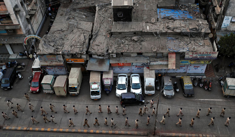 Keeping control: Police personnel march through a street in Dharavi, Mumbai, during the lockdown. Modi convinced people that tough measures were required to control the pandemic | Reuters