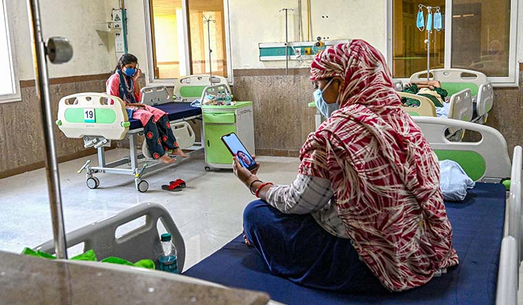 Bridging the gap: A woman suspected of having Covid-19 speaks to a relative from the isolation ward of a hospital in Jabalpur | PTI