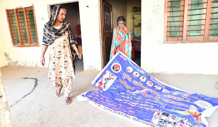 Quest for justice: Lakhbir Singh’s sister Raj Kaur and her daughter  show a poster made by a Dalit organisation demanding justice for him | Sanjay Ahlawat