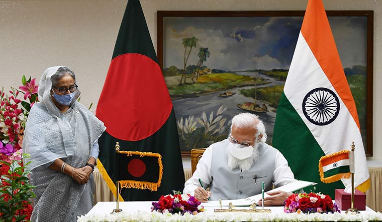 Neighbour watch: Bangladesh Prime Minister Sheikh Hasina looks on as Prime Minister Narendra Modi signs the guest book, in Dhaka, during his March visit | PTI