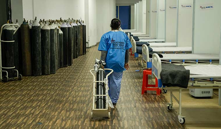 Getting battle-ready: A health worker places an oxygen cylinder at a Covid Care Centre, as part of preparedness against Omicron in Delhi | PTI
