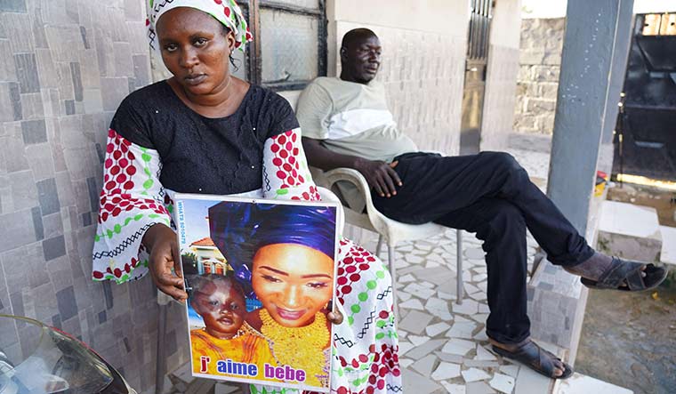 Profound loss: Mariama Kuyateh, 30, a Gambian native, holds up a picture showing her son, Musa, who died from acute kidney failure | AFP