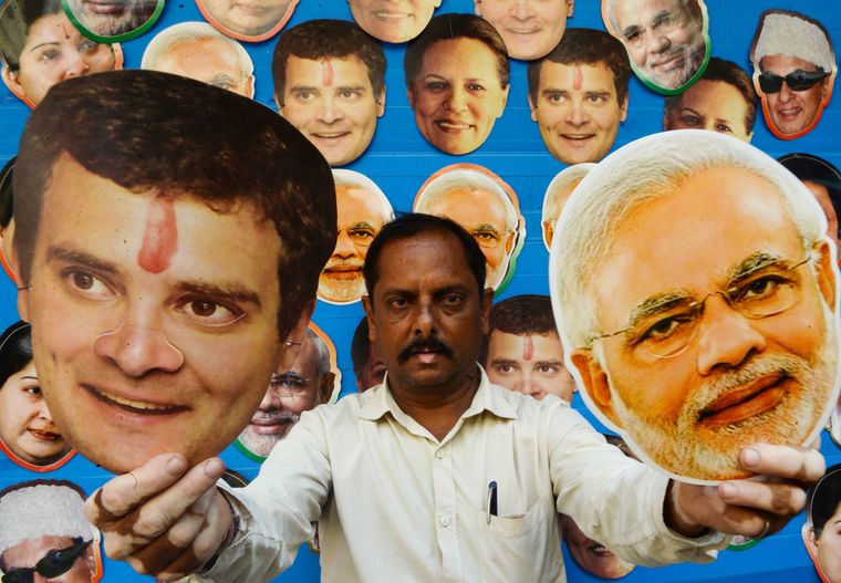 Take your pick: A shopkeeper in Chennai holding the masks of Rahul Gandhi and Narendra Modi | AFP