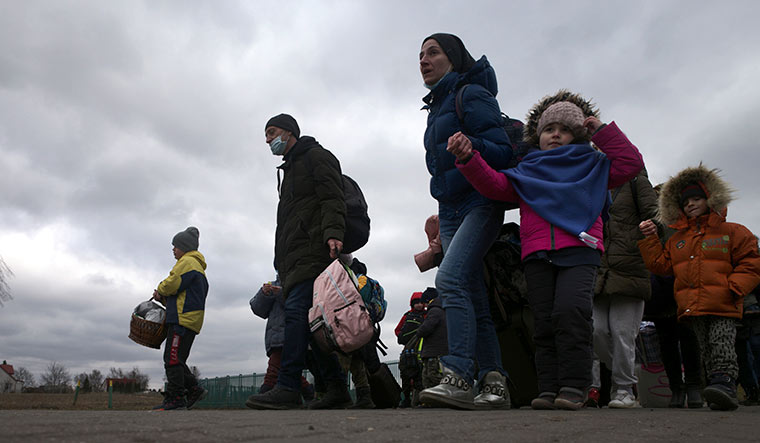Bleak skies, bleaker future: Refugees at the border crossing near Medyka. UN officials say the war has forced two million people to flee Ukraine.