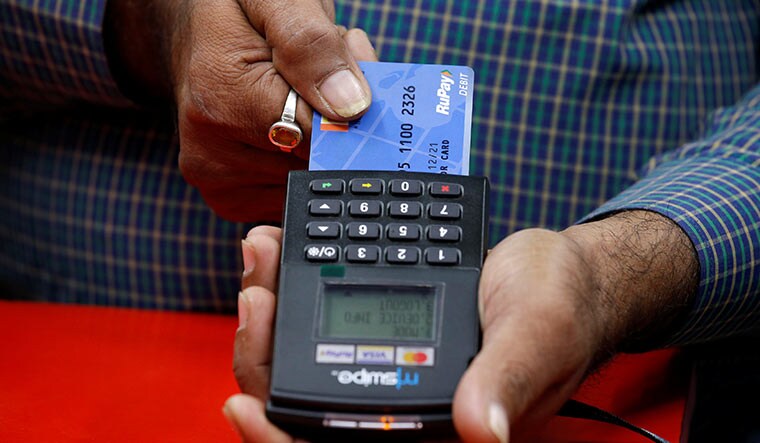 Swipe’s up: A shopkeeper swipes a customer’s debit card in Kolkata. Rupay is the market leader by numbers in india with 60 crore cards in circulation | Reuters