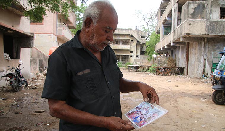 Unending anguish: Gulbarg resident Kasam Mansuri with a photograph of his family | Janak Patel