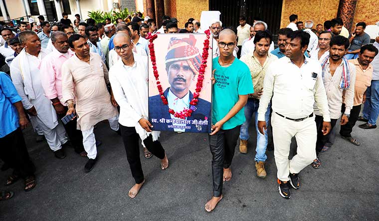 Painful farewell: Kanhaiya Lal’s sons carry their slain father’s portrait after a prayer meeting in his memory | Reuters
