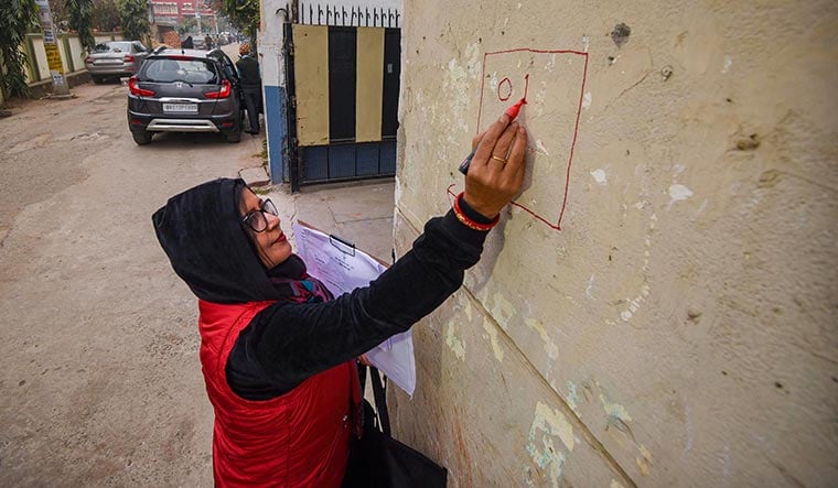 Caste and crew: An enumerator marks a house during the caste survey in Patna | PTI