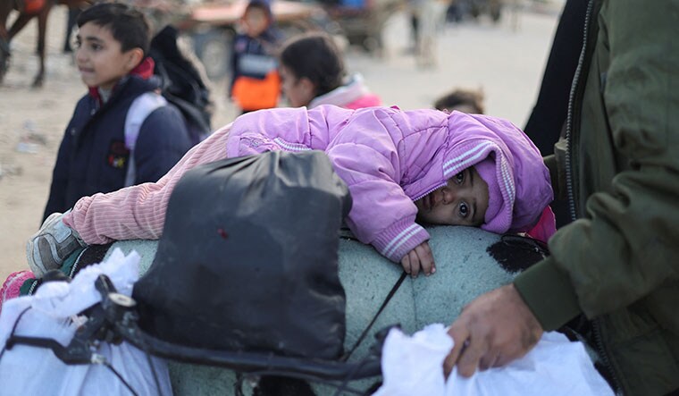 Future tense: A child lies on a bicycle packed with belongings as Palestinians flee Khan Younis towards Rafah during the Israeli ground operation in Gaza | Reuters
