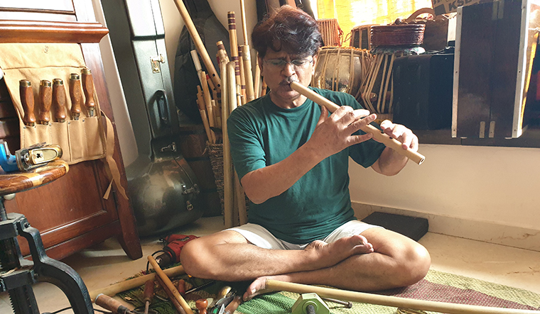 Raghubir Yadav is giving finishing touches to musical instruments like flutes and rababs that he has made from scratch.