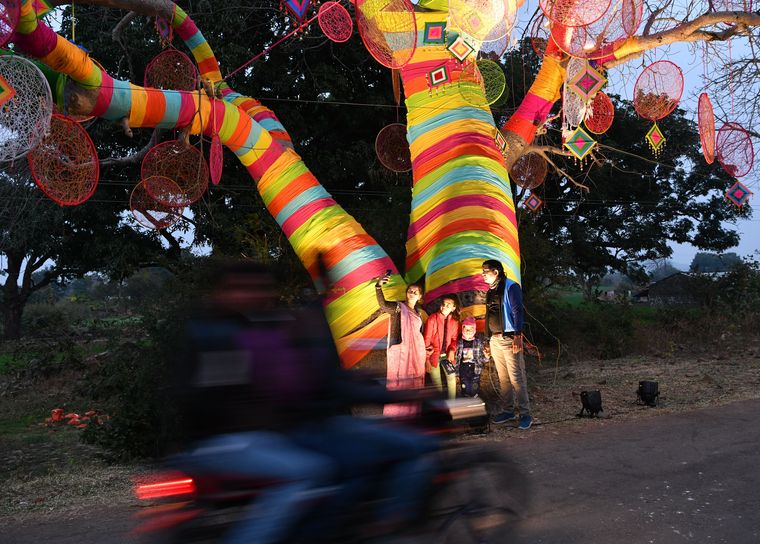 Tourists taking selfies by decorated baobab trees during the festival.