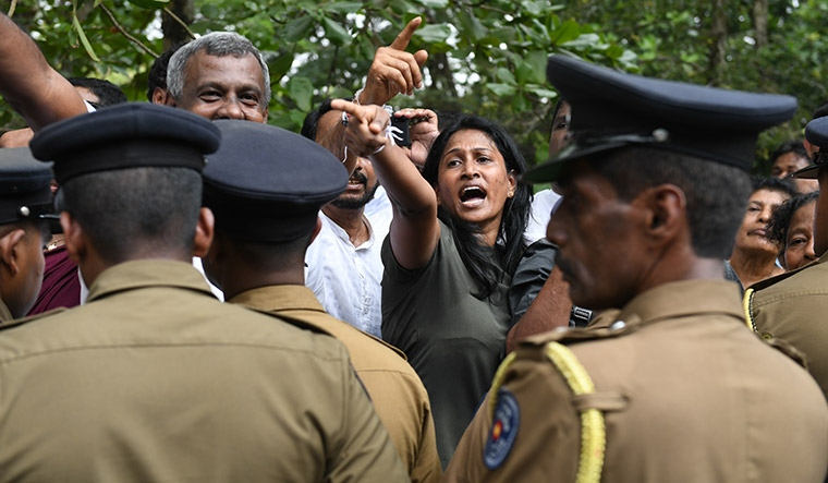 Divided we stand: Supporters of Ranil Wickremesinghe and Mahinda Rajapaksa shout slogans against each other near the Sri Lankan parliament building on November 14.