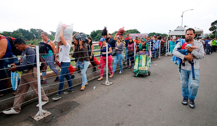 Death of a country: Venezuelans returning after buying food in the Colombian border city of Cucuta. Under Maduro, Venezuela's GDP has contracted by over 50 per cent | AFP