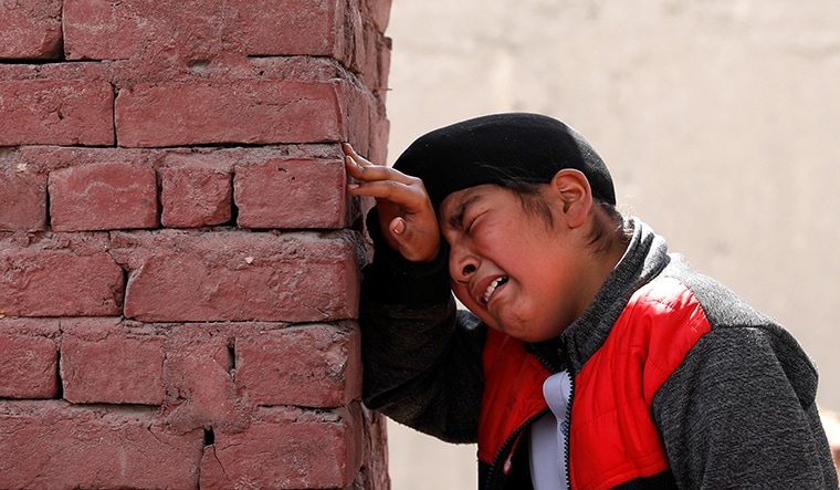 An Afghan Sikh boy mourns the victims who were killed during yesterday's attack at Sikh religious complex during a funeral in Kabul, Afghanistan March 26, 2020.REUTERS/Mohammad Ismail - RC2NRF962CDQ