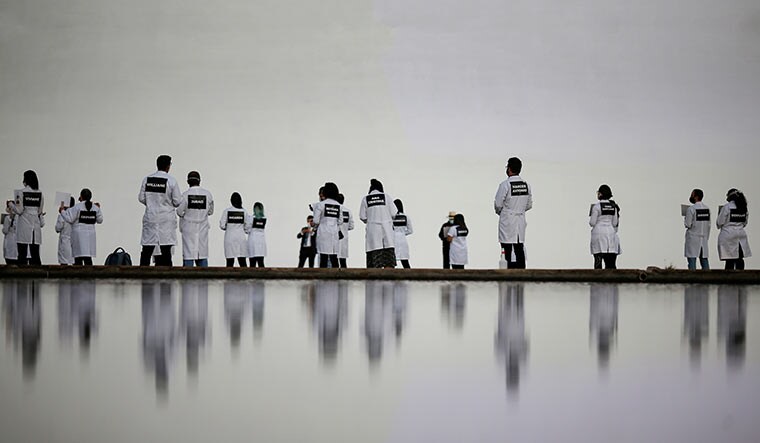 Where angels dare: Nurses wearing protective face masks participate in a protest with signs bearing the names of health care professionals who died of Covid-19 in Brasilia | Reuters