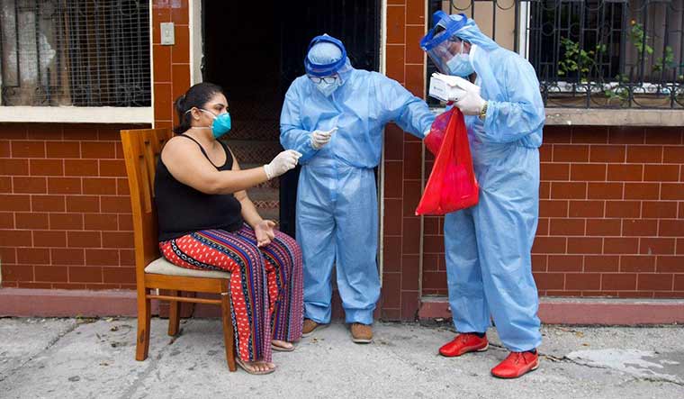 Caring hands: Health care workers collecting swab from a person in Guayaquil.