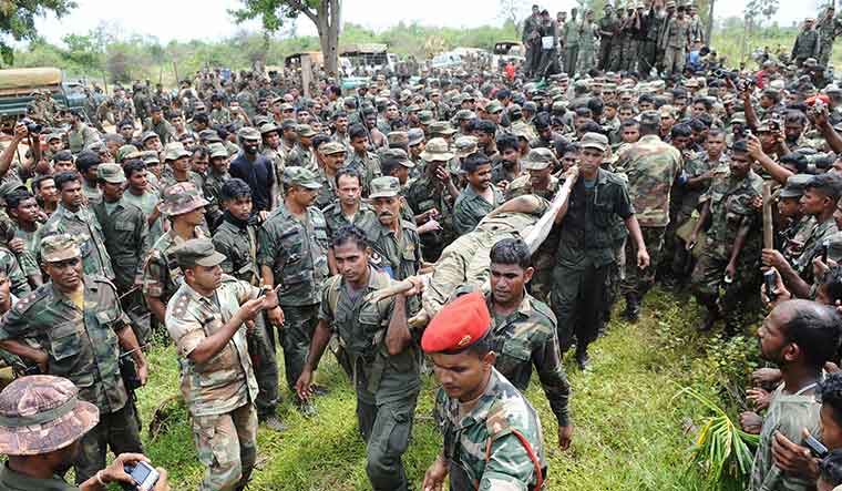 The victors and the vanquished: Sri Lankan soldiers in Mullaitivu district carrying the remains of Prabhakaran in May 2009 | AFP