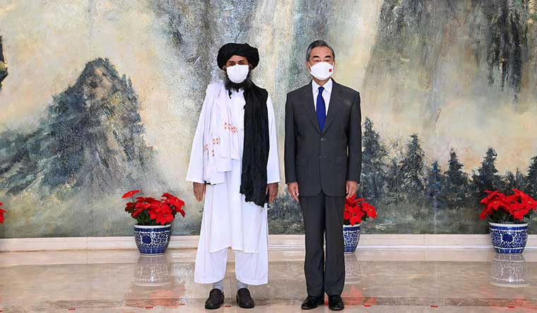 Friends with benefits: Chinese Foreign Minister Wang Yi with Mullah Abdul Ghani Baradar, political chief of Afghanistan's Taliban, in Tianjin | AFP