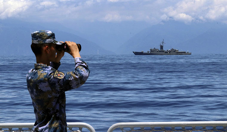 Close watch: A Chinese soldier watching military exercises as Taiwan's frigate Lan Yang is seen at the rear | AP