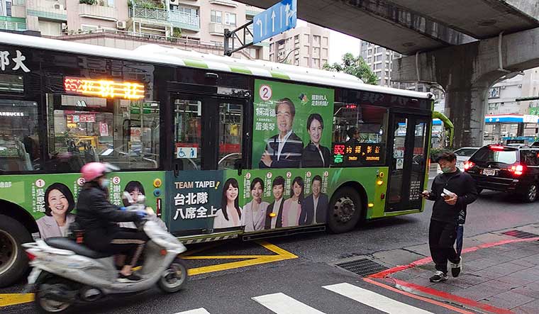 Moving ahead: Posters of candidates in the Taiwanese elections pasted on a bus in Taipei | AP